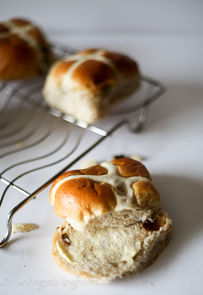 Inside a hot cross bun showing soft fluffy crumb and dried fruit pieces
